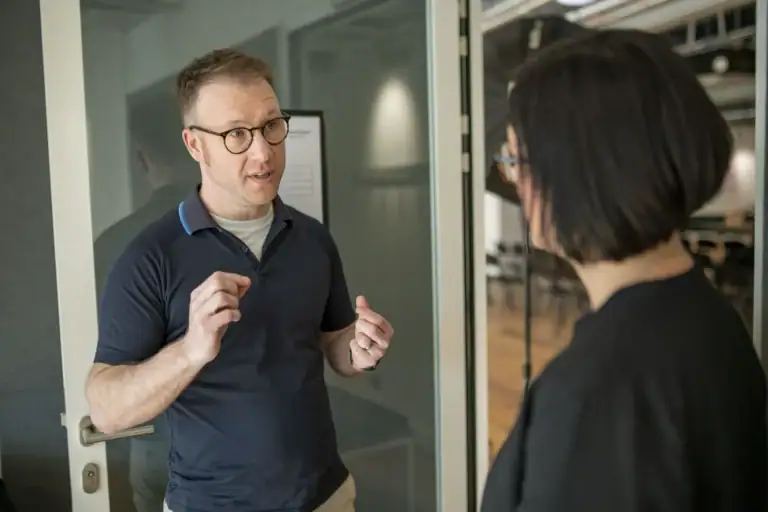 Zwei Personen im Gespräch, Fokus auf Neurodiversität und Inklusion.